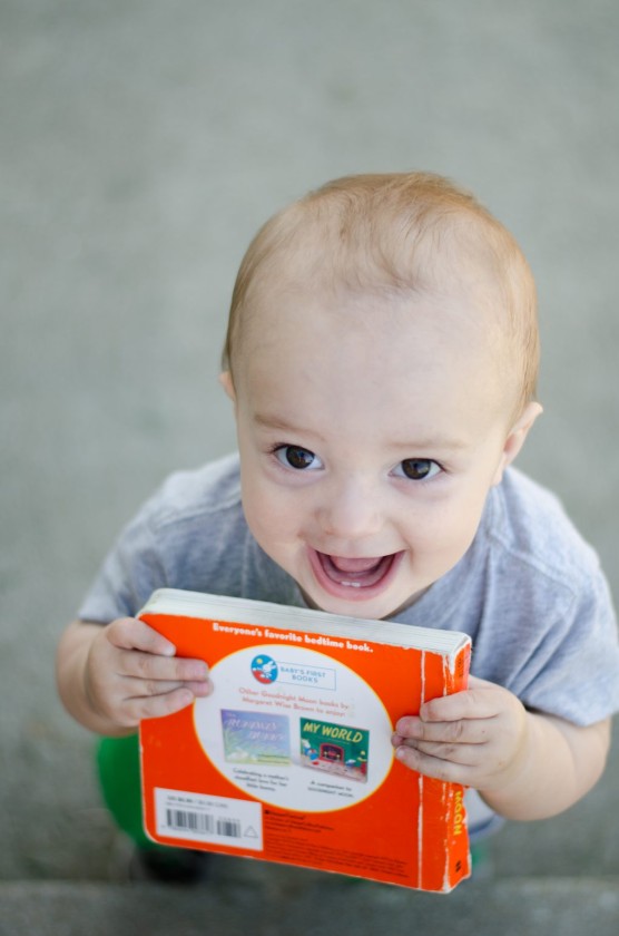 Finn, mid-laugh, smiling at the camera and acting like he's going to bite his book.