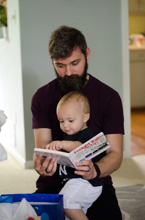 Finn, pointing at the page while daddy reads his train book