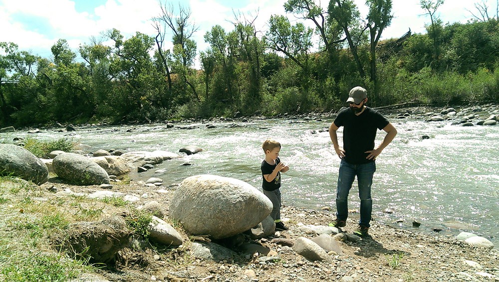 Miles picking rocks to throw into the river.