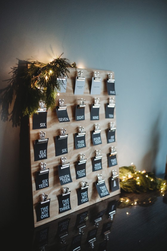 black advent activity cards clipped to wooden board - advent calendar