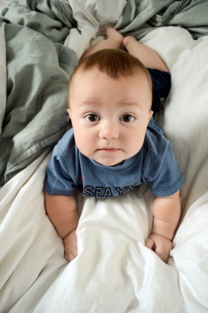 Miles - 9 Month baby photos - Looking up at me while he tries to crawl on the bed