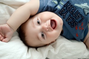 Miles - 9 Month baby photos - Laying on the bed while he looks back and laughs at me