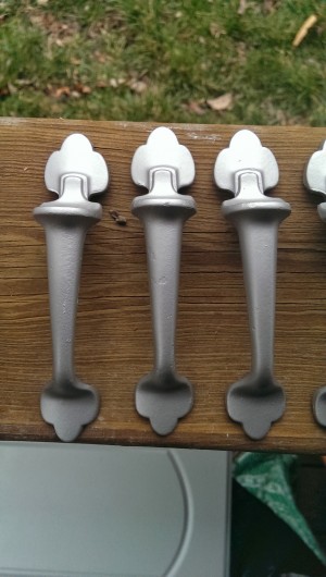 Three of the cabinet handles after being painted.