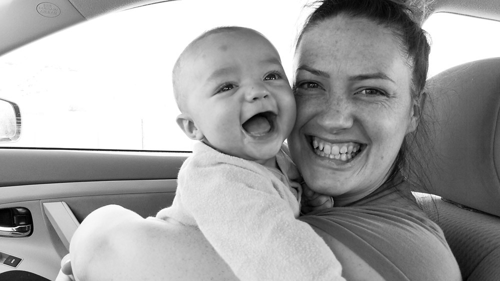 Black and white of Mom and Finn smiling in the front seat