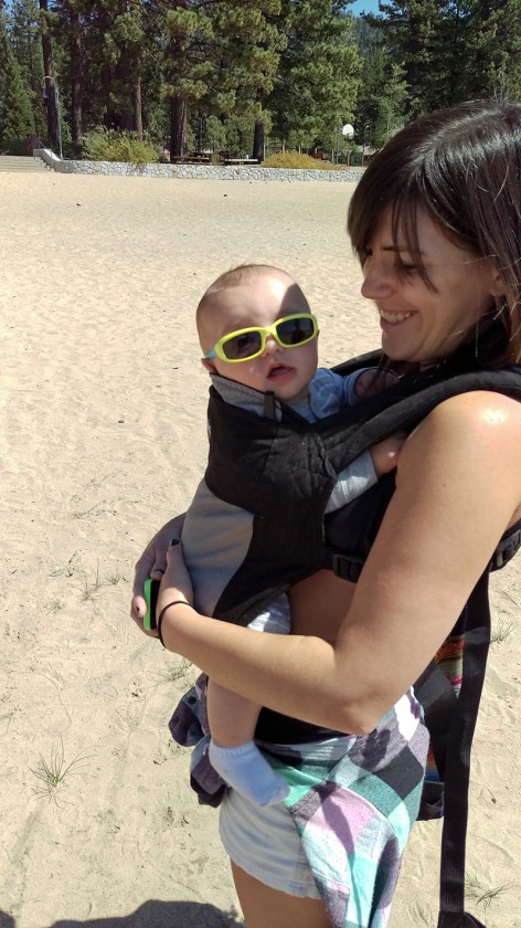 Finn wearing sunglasses while Brooke carries him on the beach