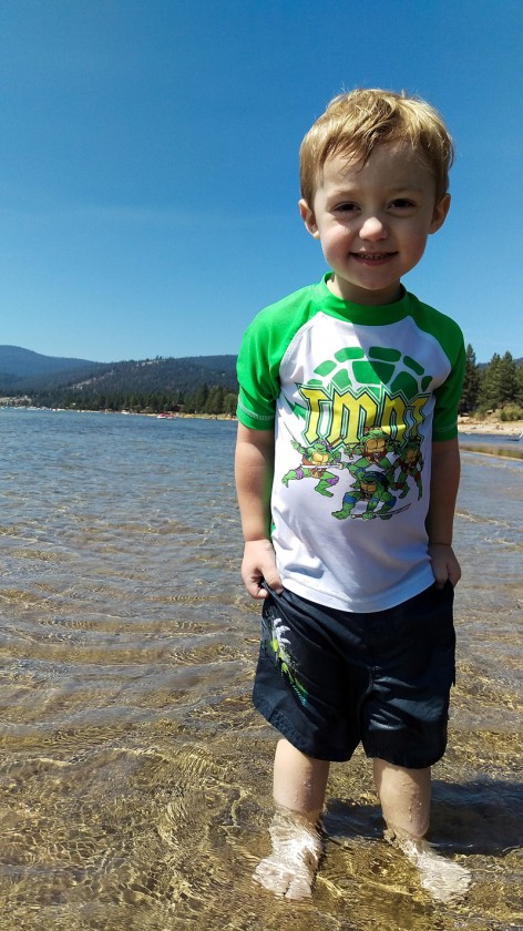 Miles smiling in the shallow water near the shore of Lake Tahoe