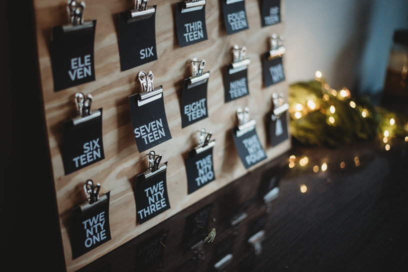 closeup of black advent activity cards arranged on a wooden board - advent calendar design